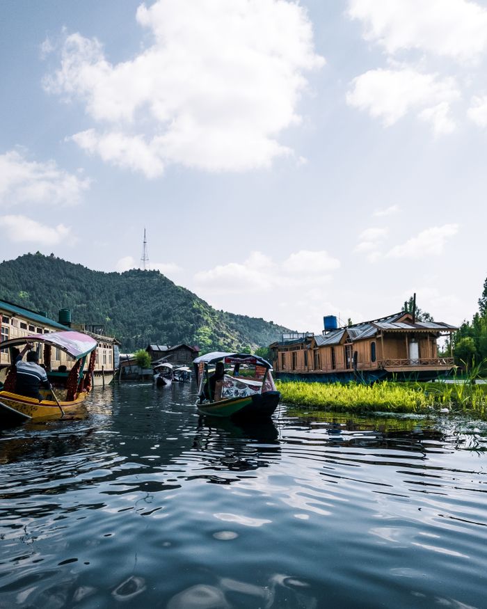 Explore tranquility on a serene mountain lake with boats and nature.