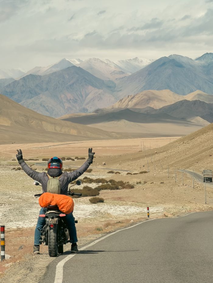 Man on a motorcycle enjoying freedom on a scenic Himalayan mountain road.