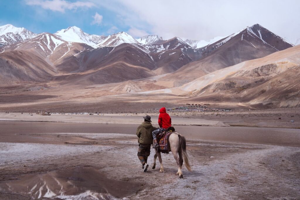 Mastering the First Impression: Your intriguing post title goes here A person and child riding a horse in the breathtaking mountains of Ladakh, India.